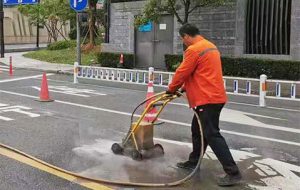 Road marking removal high pressure jetting machine working on city road pavement